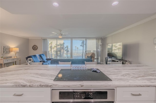 kitchen with black electric cooktop, ceiling fan, stainless steel oven, and white cabinets