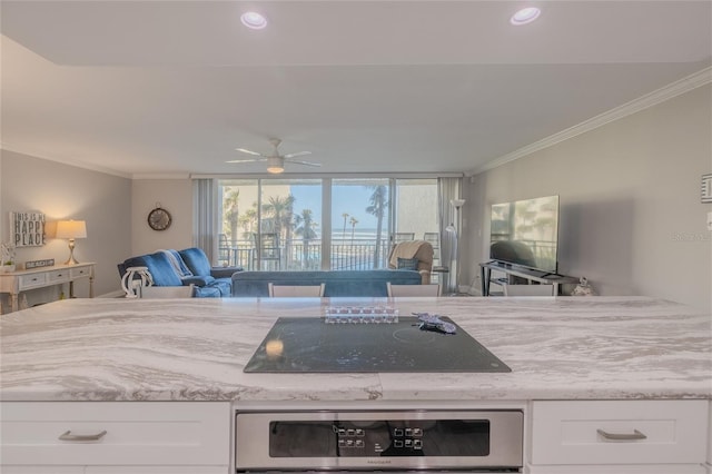 2401 S Atlantic Ave Unit C206, New Smyrna Beach, FL 32169 - kitchen featuring open floor plan, oven, white cabinets, crown molding, and black electric stovetop