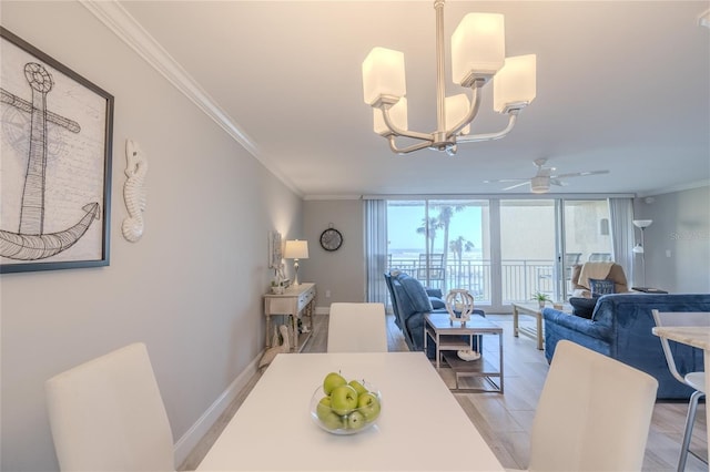 dining room with ceiling fan with notable chandelier, expansive windows, light wood-type flooring, and crown molding