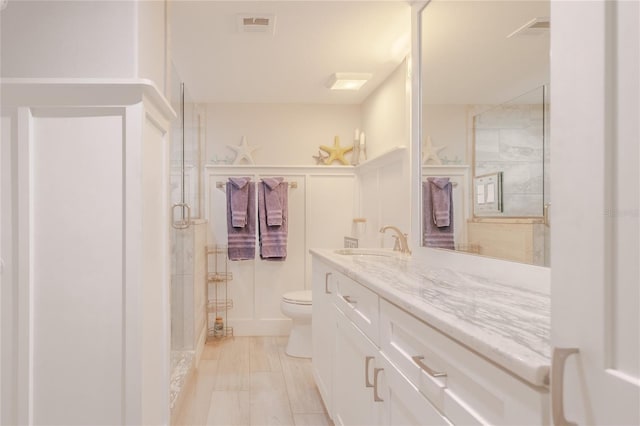 bathroom featuring vanity, toilet, and an enclosed shower