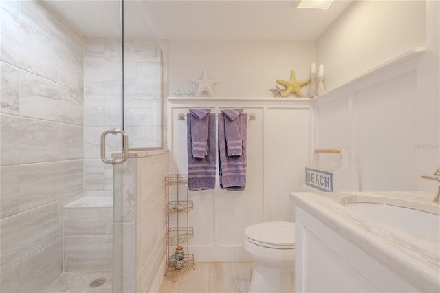 bathroom featuring vanity, toilet, wood-type flooring, and walk in shower