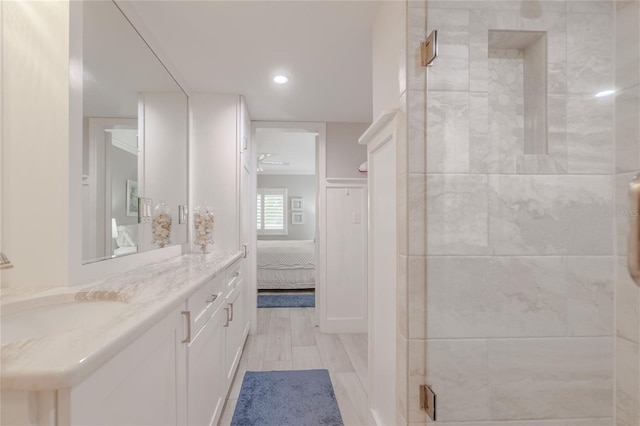 bathroom featuring wood-type flooring, vanity, and walk in shower