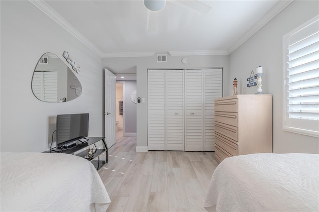 bedroom with ceiling fan, light hardwood / wood-style floors, crown molding, and a closet