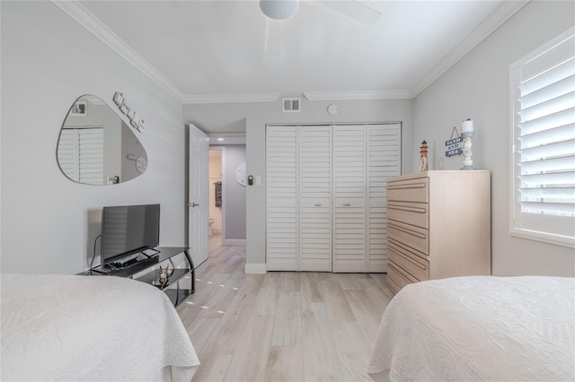2401 S Atlantic Ave Unit C206, New Smyrna Beach, FL 32169 - bedroom featuring a closet, crown molding, light wood-type flooring, and a ceiling fan