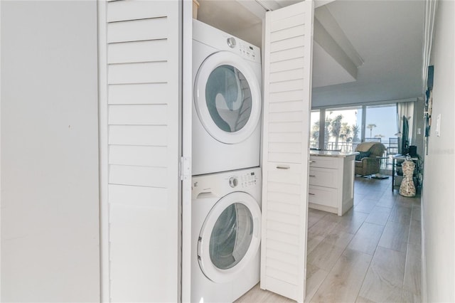 clothes washing area with stacked washer / dryer and light hardwood / wood-style floors