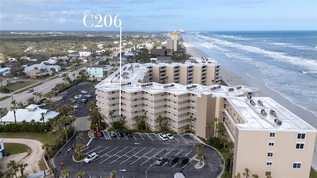 drone / aerial view featuring a beach view and a water view