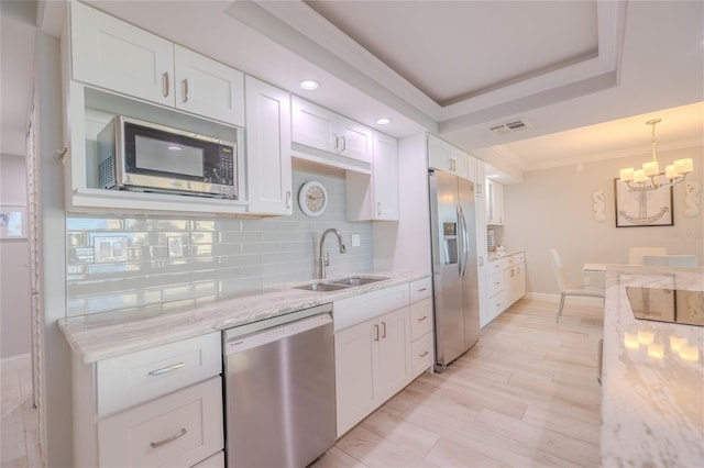 2401 S Atlantic Ave Unit C206, New Smyrna Beach, FL 32169 - kitchen featuring appliances with stainless steel finishes, white cabinetry, a chandelier, backsplash, and ornamental molding
