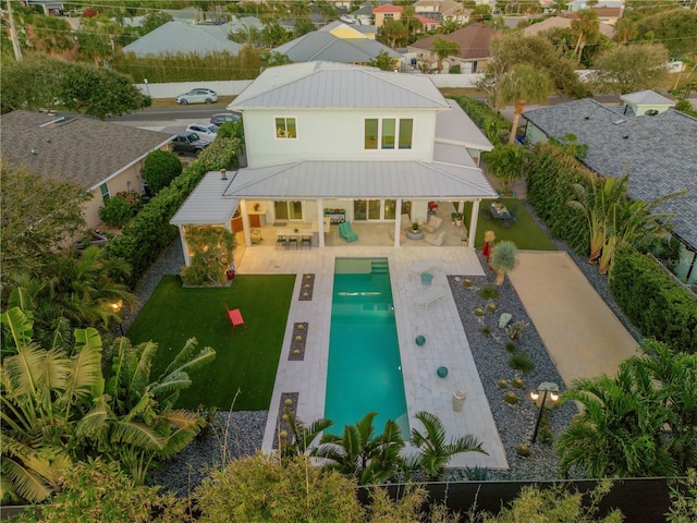 back of house with an outdoor living space, a fenced in pool, and a patio area