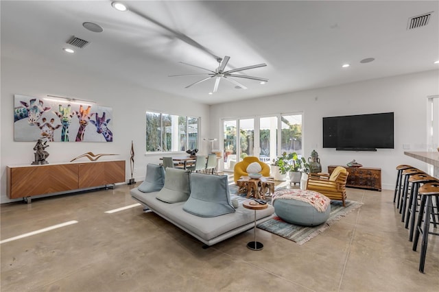 living room featuring ceiling fan and concrete flooring