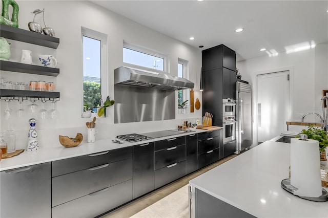 kitchen featuring stainless steel appliances, sink, light tile patterned floors, and extractor fan