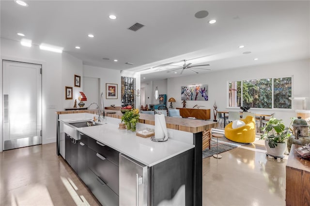 kitchen with a large island, sink, and ceiling fan