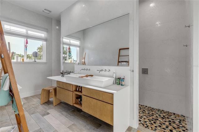 bathroom featuring a tile shower and vanity