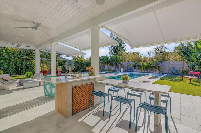 view of patio featuring ceiling fan and an outdoor bar