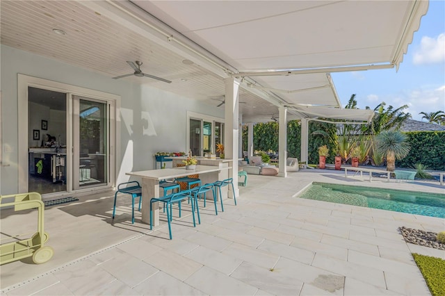 view of swimming pool featuring ceiling fan, an outdoor bar, and a patio