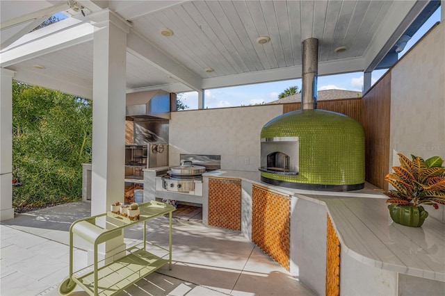 view of patio with an outdoor kitchen and exterior fireplace