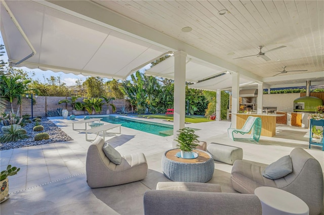 view of patio with exterior bar, an outdoor living space, ceiling fan, exterior kitchen, and a fenced in pool