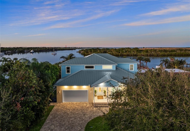 view of front of home with a garage and a water view