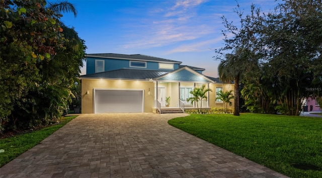 view of front of home with a garage and a yard