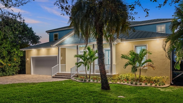 view of front of house with a garage and a lawn