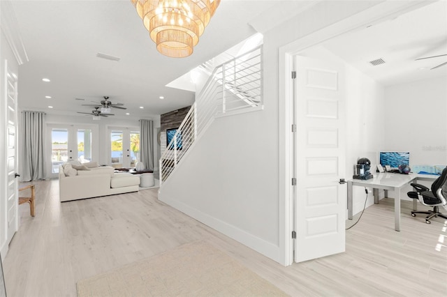 stairway with ceiling fan with notable chandelier, wood-type flooring, and french doors