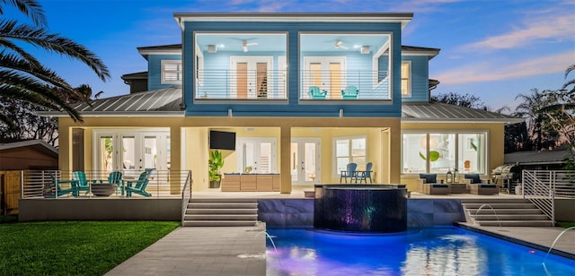 rear view of property featuring pool water feature, french doors, a balcony, and an outdoor living space