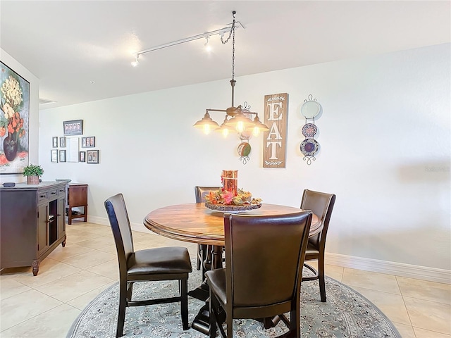 tiled dining area with rail lighting and an inviting chandelier