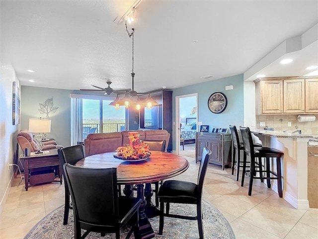 tiled dining space with ceiling fan