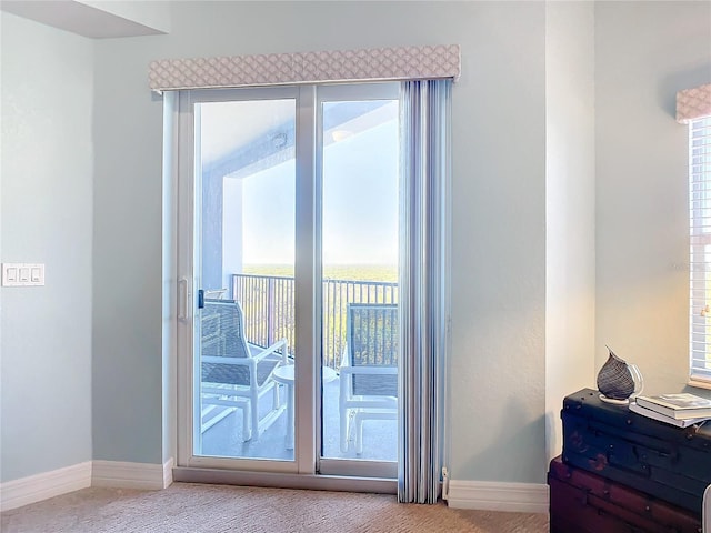 doorway featuring light carpet and plenty of natural light