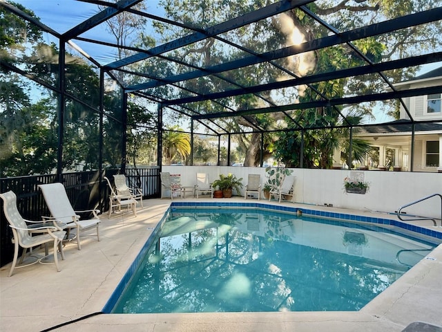 view of swimming pool featuring a patio and glass enclosure