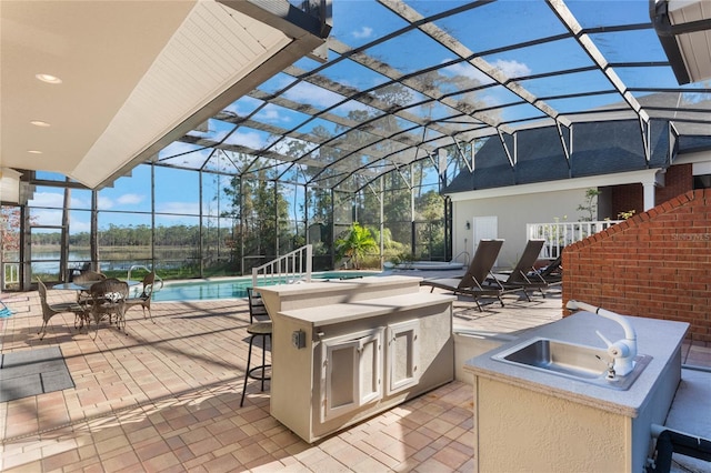 view of patio with area for grilling, a lanai, and a wet bar