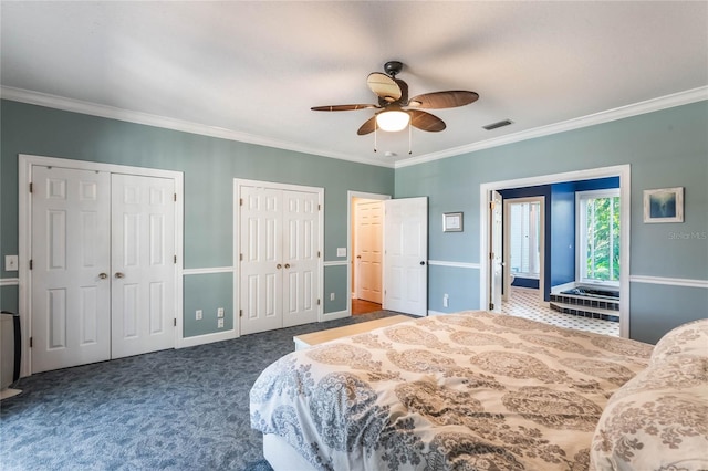 bedroom with dark carpet, ceiling fan, multiple closets, and crown molding