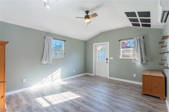 foyer entrance featuring a wealth of natural light, ceiling fan, lofted ceiling, and light wood-type flooring