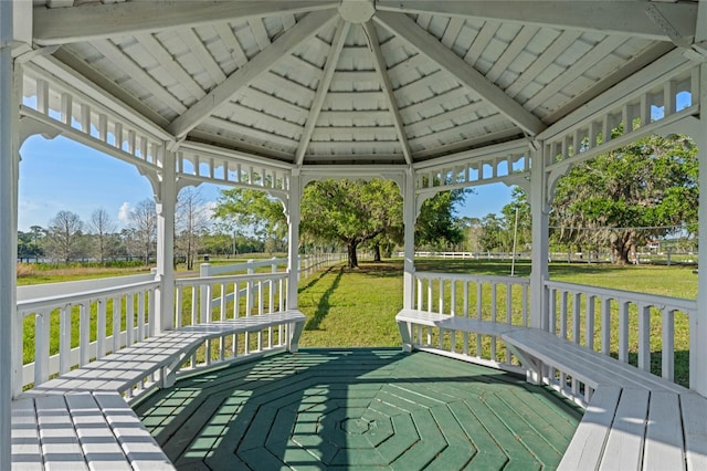 wooden terrace with a gazebo and a lawn