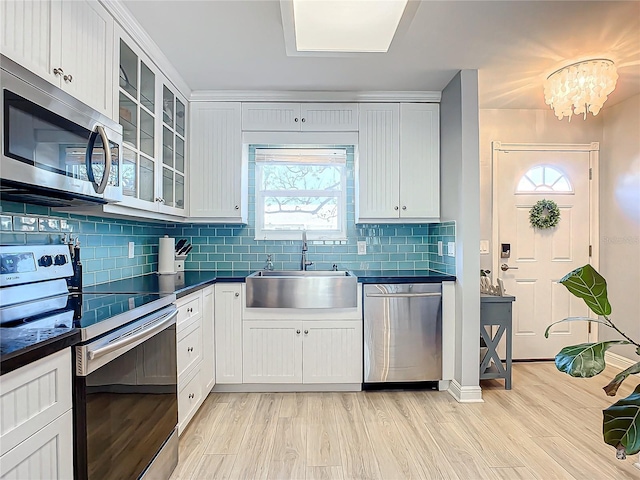 kitchen featuring stainless steel appliances, tasteful backsplash, sink, and white cabinets