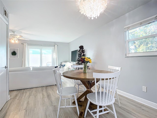 dining room featuring ceiling fan with notable chandelier and light wood-type flooring