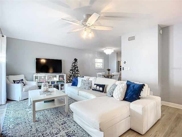 living room featuring ceiling fan and light wood-type flooring