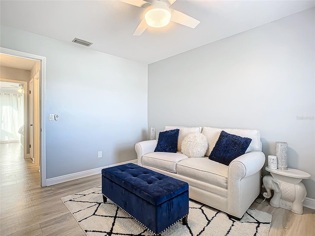 living room featuring ceiling fan and light hardwood / wood-style flooring