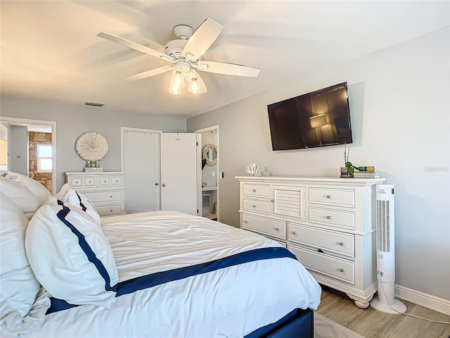 bedroom with hardwood / wood-style floors, ceiling fan, and ensuite bathroom