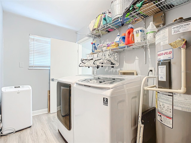 laundry room with light hardwood / wood-style floors, water heater, and washing machine and clothes dryer