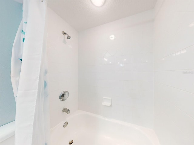 bathroom featuring shower / bath combination with curtain and a textured ceiling