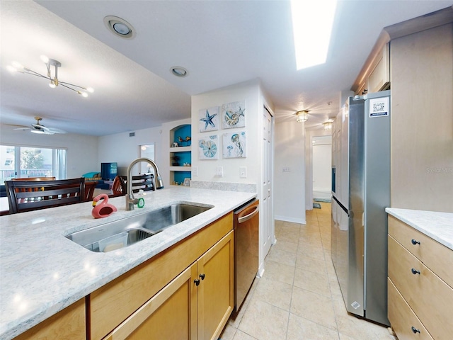 kitchen featuring sink, ceiling fan, light tile patterned floors, light stone countertops, and appliances with stainless steel finishes