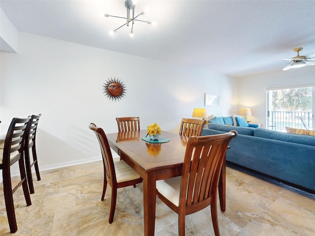 dining space featuring ceiling fan with notable chandelier