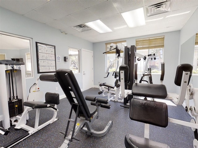 workout area featuring a paneled ceiling and a healthy amount of sunlight