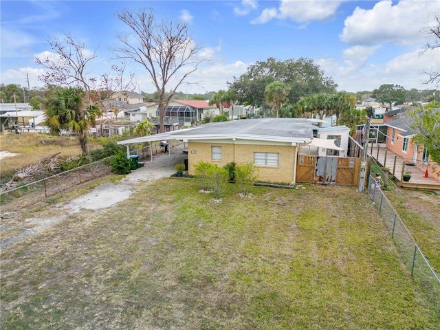 rear view of property featuring a lawn and a carport