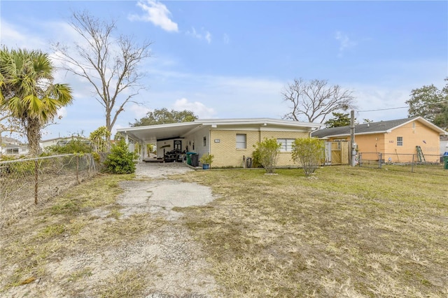 back of house with a lawn and a carport