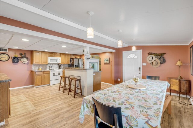 dining room featuring crown molding and light hardwood / wood-style flooring