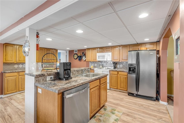 kitchen featuring light hardwood / wood-style floors, sink, stainless steel appliances, and tasteful backsplash