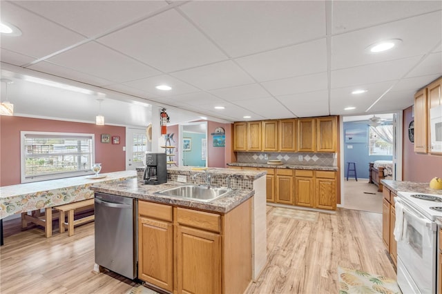 kitchen with dishwasher, light hardwood / wood-style floors, hanging light fixtures, and an island with sink