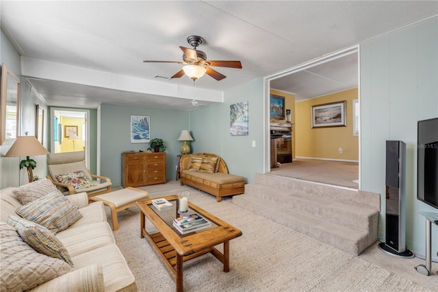 carpeted living room with a textured ceiling and ceiling fan