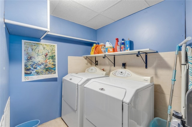 laundry area featuring independent washer and dryer and tile walls